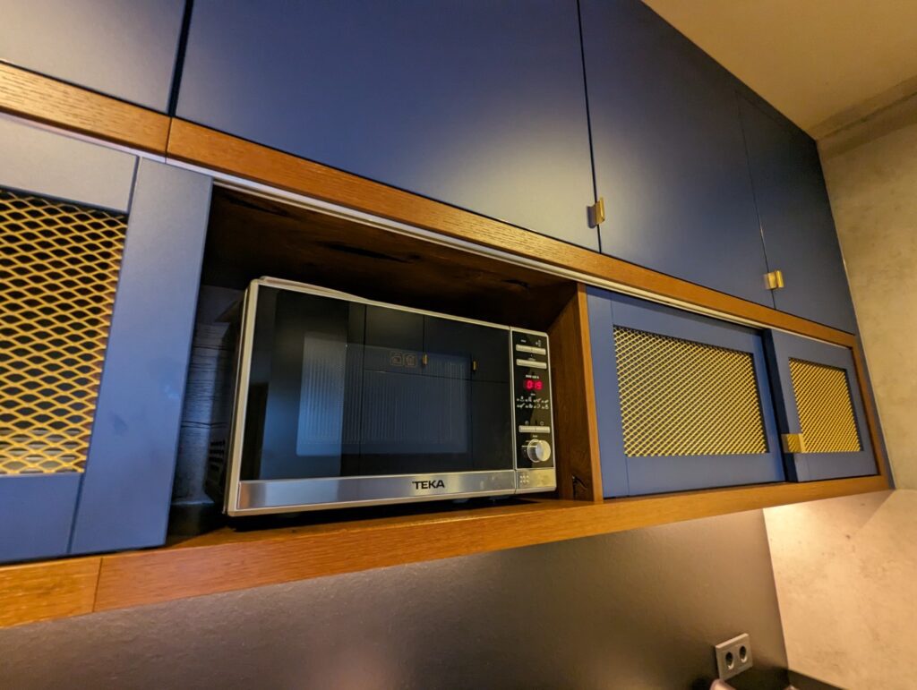 Microwave set into blue cupboards in the fully stocked Berlin Apartments Mitte- Wedding location