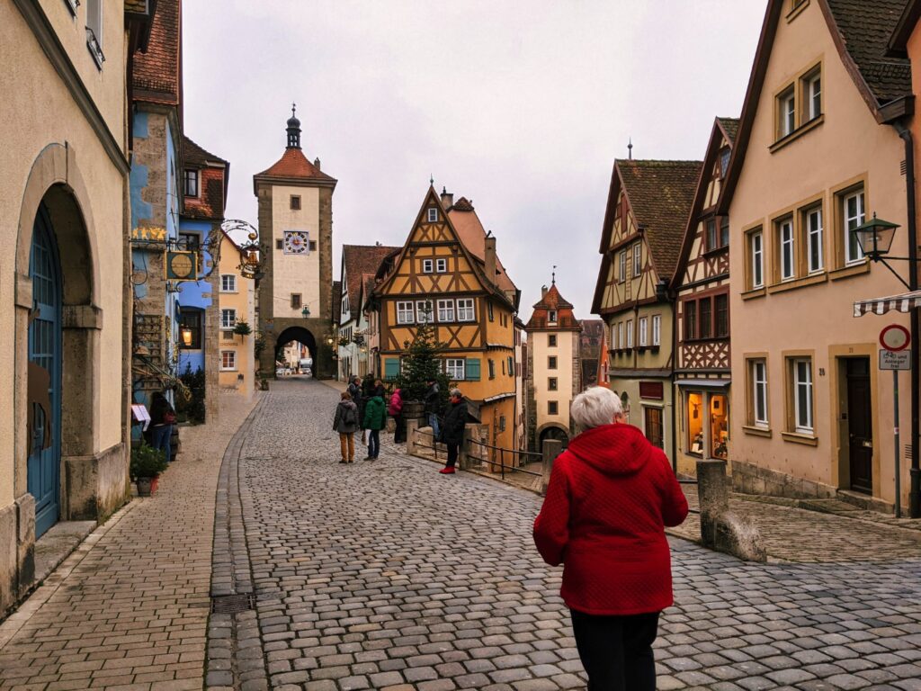 women in red coat walking around the christmas market in rothenburg Germany