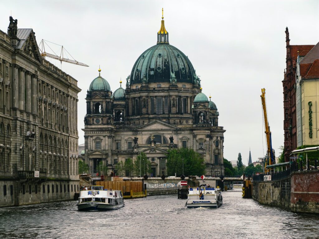 Berlin River Spree with 2 boats in river and Berlin Cathedral in background