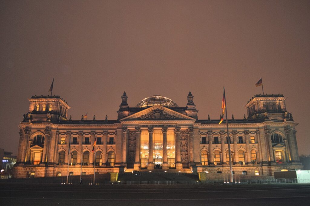 berlin reichstag at night lit up in an orange hue 