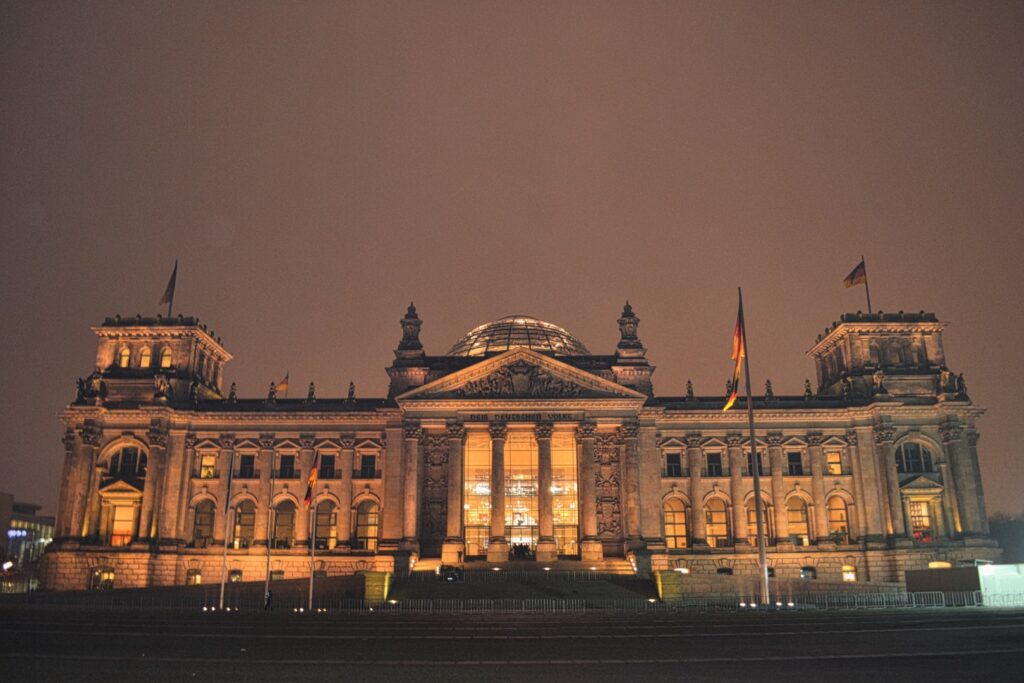berlin reichstag at night lit up in an orange hue