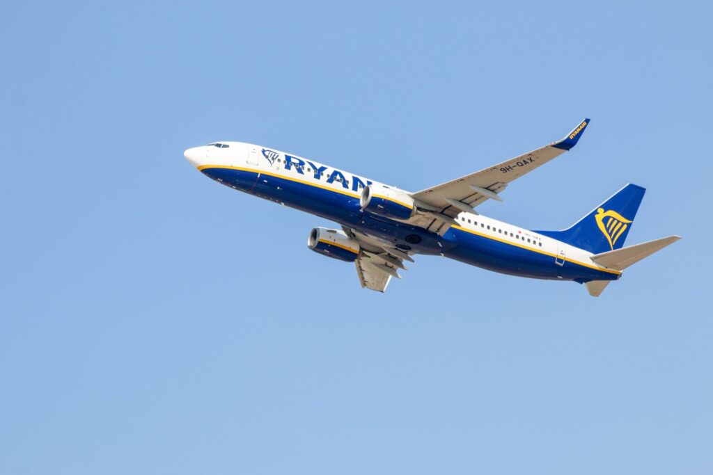 ryan air plane flying in the air with a blue sky behind